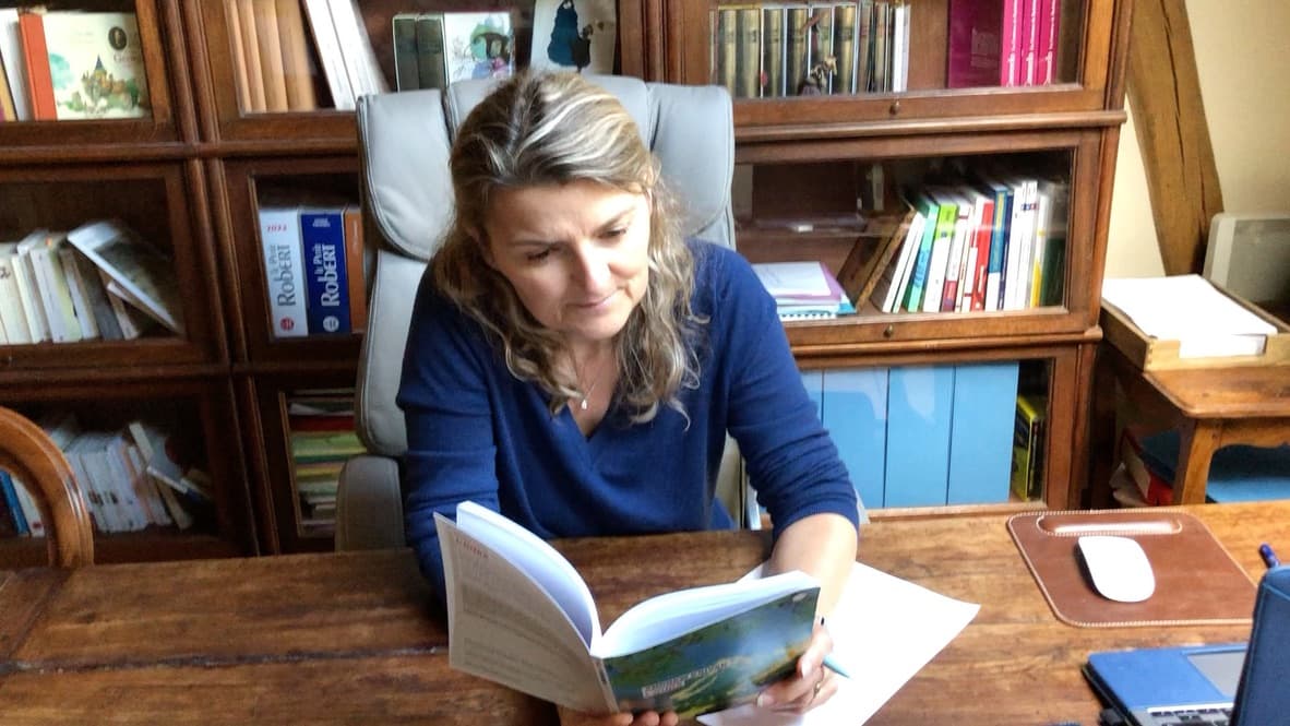Domitille Raillon relit un livre broché à son bureau